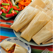 Plate of corn husks with a doughy vegetable filling.