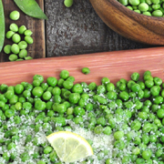 Platter of peas and parmesan with a lemon slice.