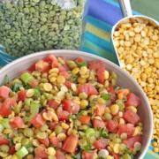 Bowl with a vibrant mix of split peas, tomato and parsley.