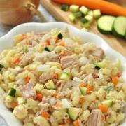 Bowl of macaroni noodles with tuna and vegetable cubes.