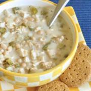 Small bowl of creamy chicken and bean soup served with crackers.