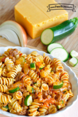 Tazón pequeño de pasta en espiral con salsa roja, carne de res y calabacita.