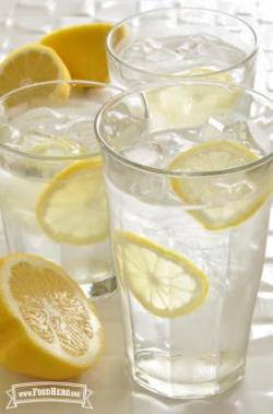 Glasses of ice water with thin lemon slices.