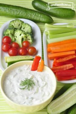 Yogurt dip served with a plate of sliced vegetables.