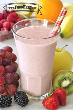 Thick pink smoothie in a glass with a straw.