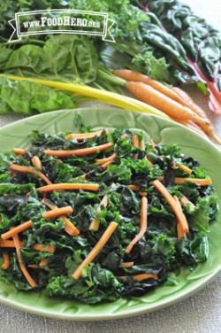 Plate of kale and carrot strips with dressing. 