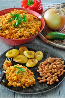 Un tazón grande de arroz Jollof acompañado con plátanos verdes y frijoles.