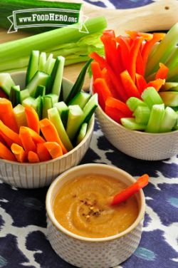 Bowl of Peanut Sauce shown with bowls of raw vegetables for dipping.