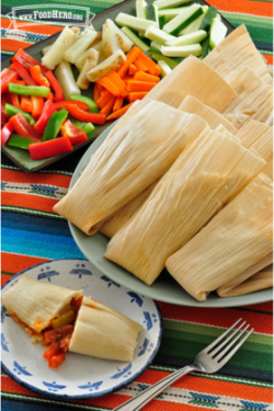 Plate of corn husks with a doughy vegetable filling.