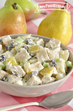 Bowl of pear salad with a creamy dressing and raisins.