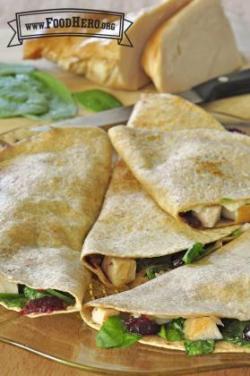 Plate of golden tortillas folded over turkey, cranberry and spinach filling.