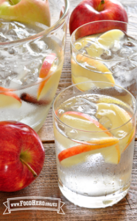 Se muestran vasos de refrescante Agua con Sabor a Manzana y Canela con guarnición de rodajas de manzana.