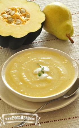 A bowl of smooth squash soup spiced with ginger and garlic is topped with yogurt and chopped parsley.