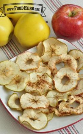 Slices of dried apples sprinkled with cinnamon are displayed on a platter.