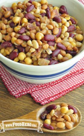 A mixture of seasoned beans and bacon is shown in a serving bowl.