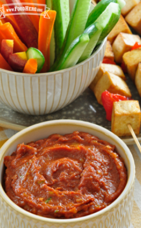 A bowl of banana ginger sauce is shown with raw veggie strips and grilled tofu kebabs for dipping.