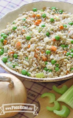 Mix of bulgur with savory vegetables is displayed in a serving dish.