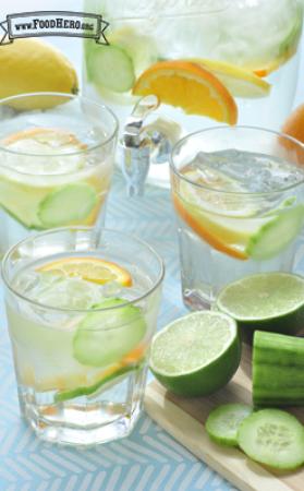 Glasses of water with floating cucumber, lime and lemon slices. 