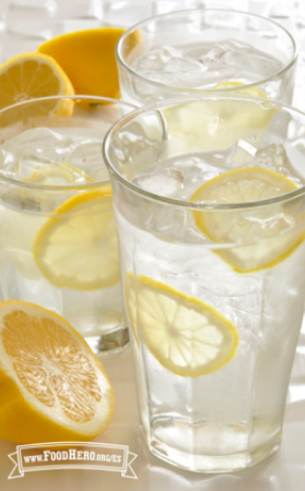   Vasos de agua helada con rodajas delgadas de limón amarillo.