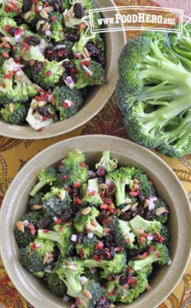 A bowl is filled with crunchy salad featuring broccoli, raisins and sunflower seeds.