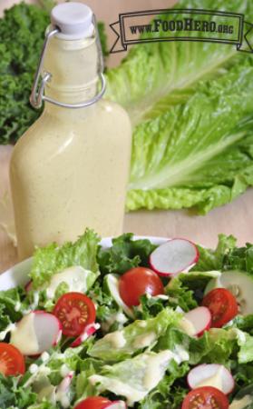 Bottle of dressing displayed with a salad.