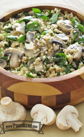 A wooden bowl with bulgur, mushrooms and spinach.