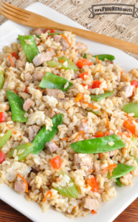 Plato colorido de arroz salteado, cerdo y verduras con glaseado de salsa de soya.