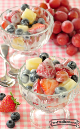 Vasos de postre rellenos con una mezcla de frutas recubierta de yogur.  