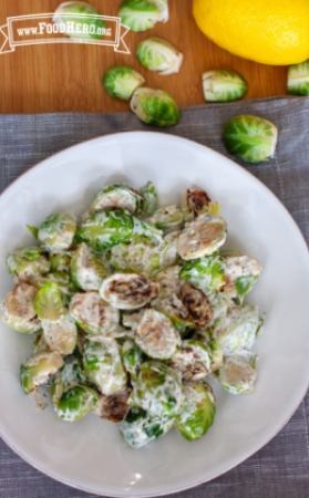 Plate of brussels sprouts with a creamy yogurt dressing.