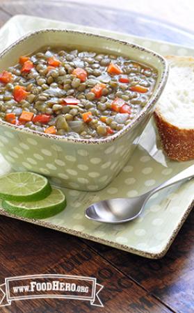 Lentil, carrot and bell pepper soup served with lime and a slice of bread.