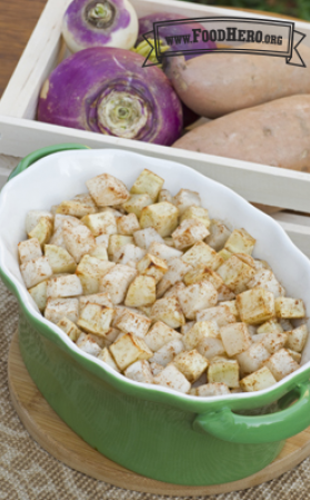Baking dish filled with sweet potatoes and turnips sprinkled with cinnamon.