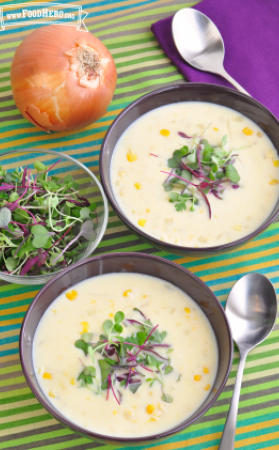 Bowls of creamy corn soup garnished with microgreens. 