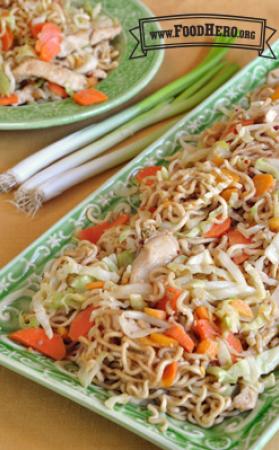 Plate of stir-fried noodles with chicken and vegetables.