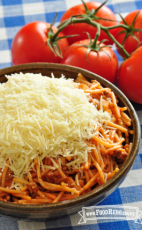 Tazón grande de espaguetis cubiertos con queso parmesano rallado.