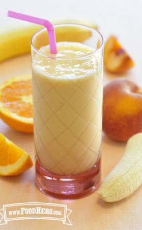 Glass of a creamy orange smoothie with a straw.