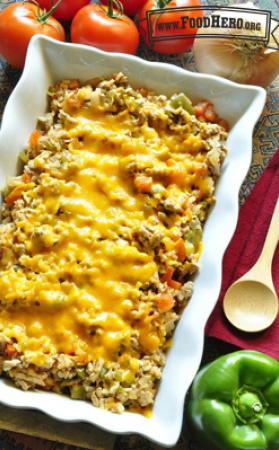 Casserole dish with rice, beef and vegetables with melted cheddar cheese. 