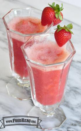 Frothy pink strawberry drinks in glasses. 