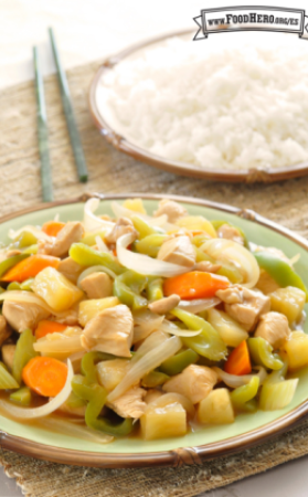 Plato con piña picada, verduras y pollo servido con arroz.