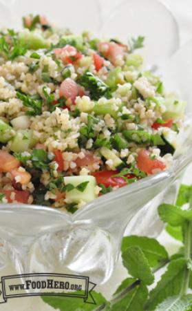 Bowl of vegetables with bulgur and dressing.