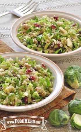 Dishes of salad featuring Brussels sprouts, dried cranberries and nuts mixed with a citrus dressing.