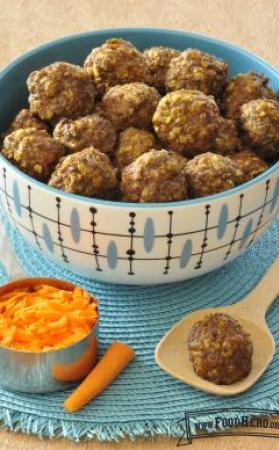 A bowl of baked meatballs made with oatmeal and grated carrot is shown on a placemat.