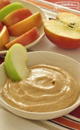 Small bowl of yogurt and peanut butter mix served with sliced apples.