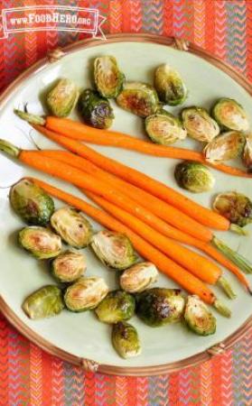 Plate of roasted thin whole carrots and brussels sprouts. 