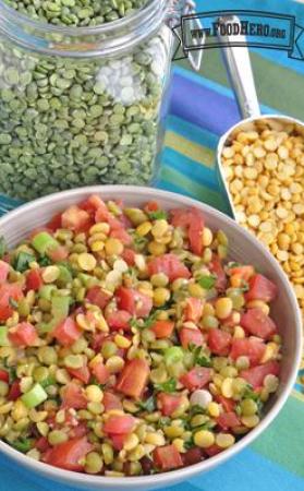 Bowl with a vibrant mix of split peas, tomato and parsley.