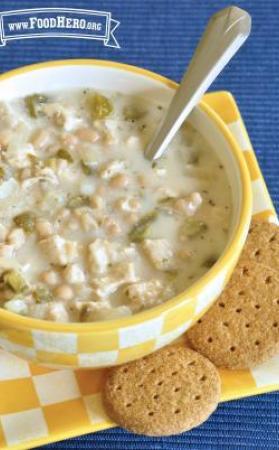 Small bowl of creamy chicken and bean soup served with crackers.