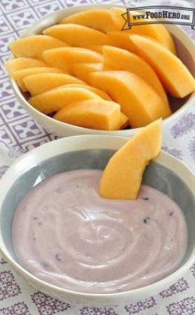Bowl of yogurt dip served with cantaloupe slices. 