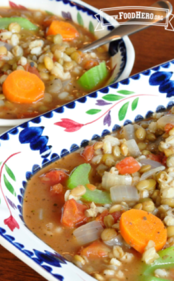 Bowls of soup containing colorful vegetables, lentils and barley.