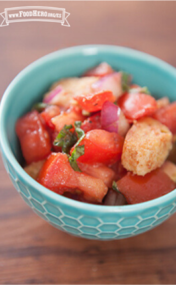 Una sabrosa ensalada de tomates, albahaca y crutones se muestra en un tazón para servir.