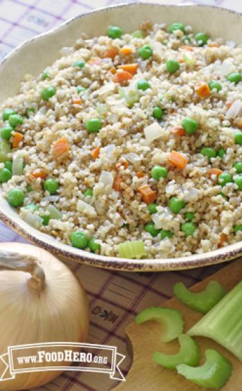 Mix of bulgur with savory vegetables is displayed in a serving dish.