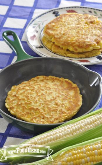 Round, golden corn pancakes displayed on a skillet and plate.